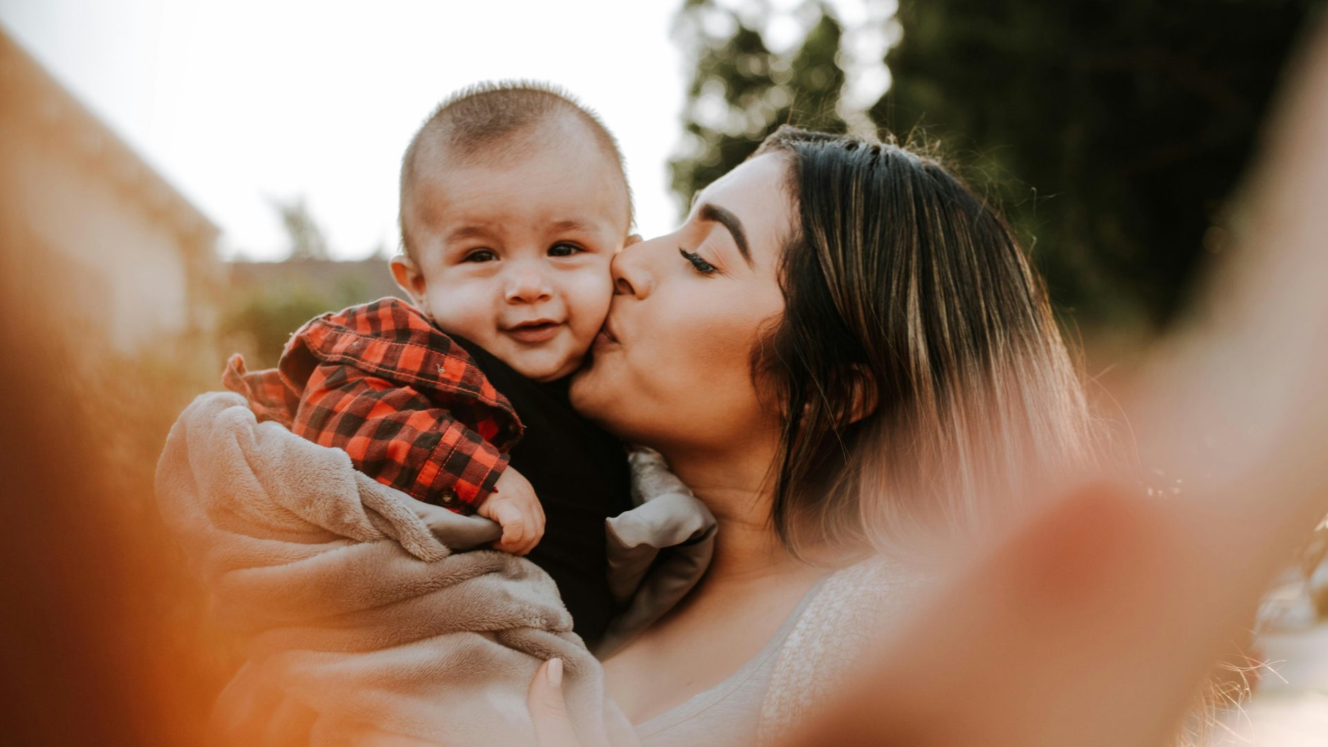 woman kiss a baby while taking picture